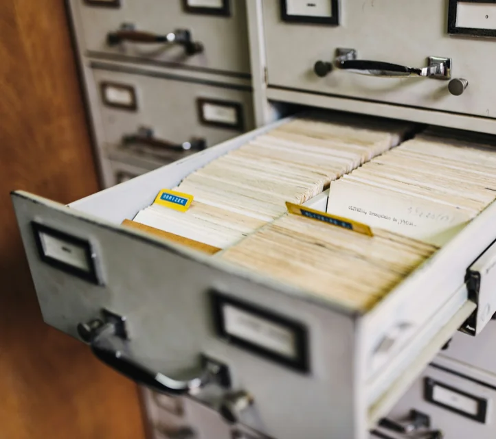 An open file drawer full of index cards