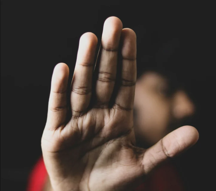 A man extending his hand in a stop gesture