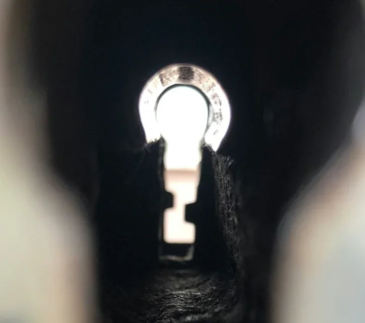 An extreme closeup of a keyhole with light showing through.