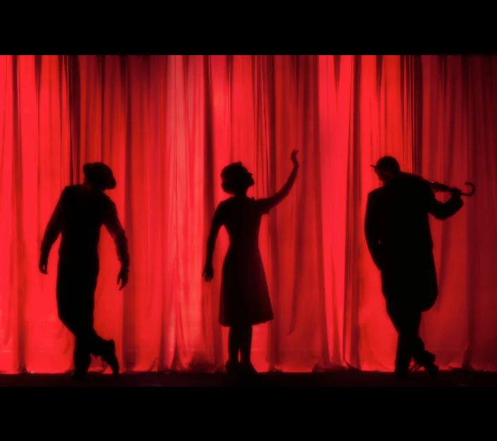 Silhouettes of actors on a stage.