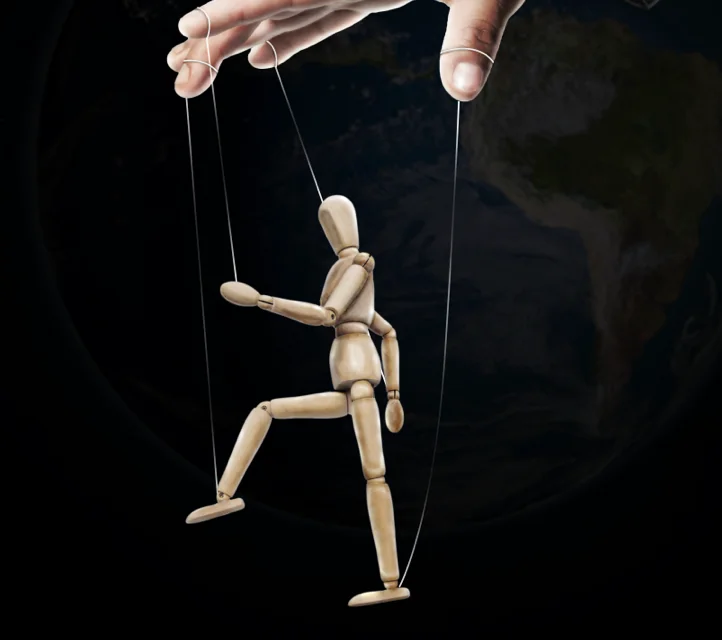 A hand operating a marionette.